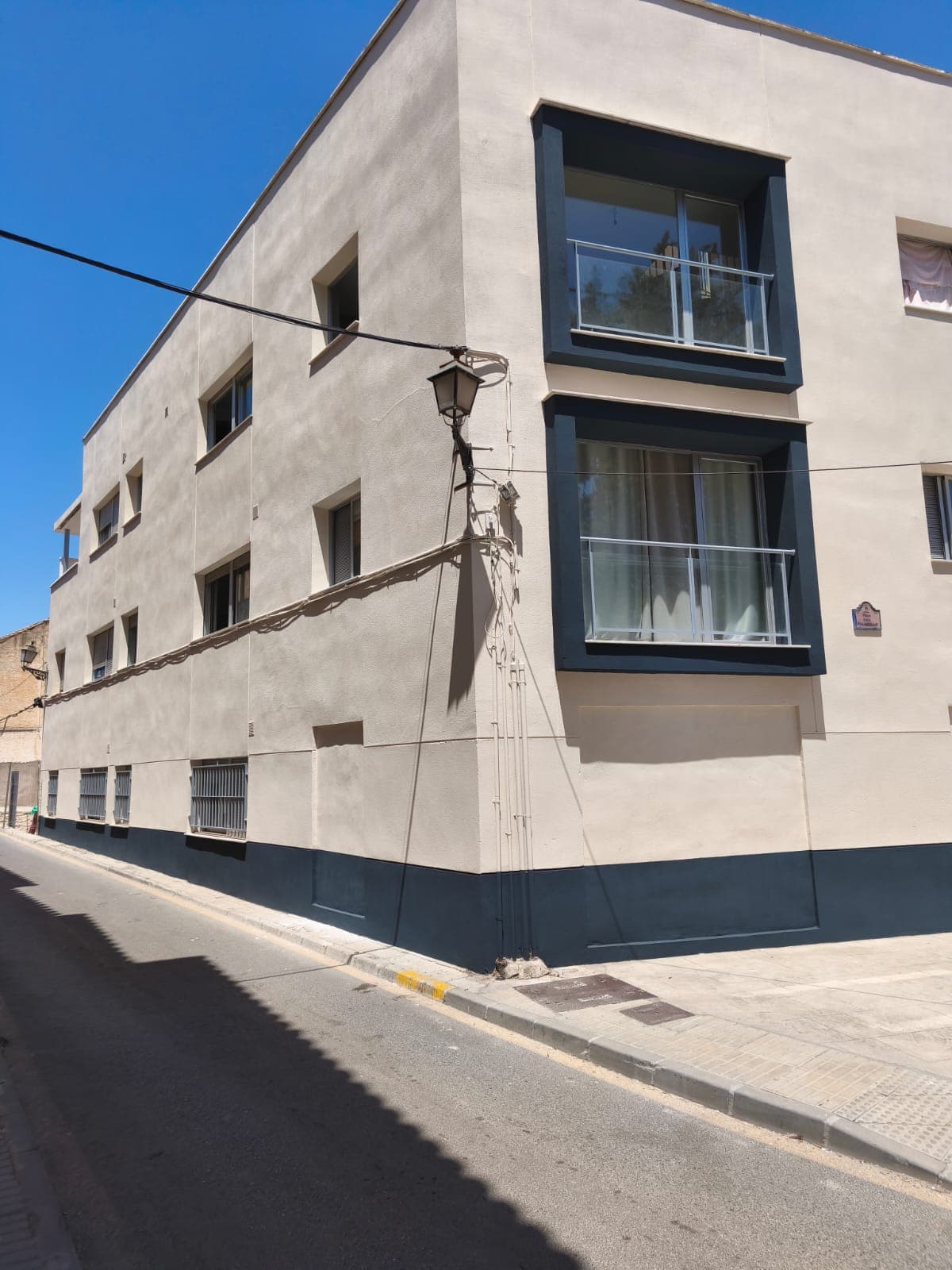 Fachada de comunidad pintada en gris claro en Granada