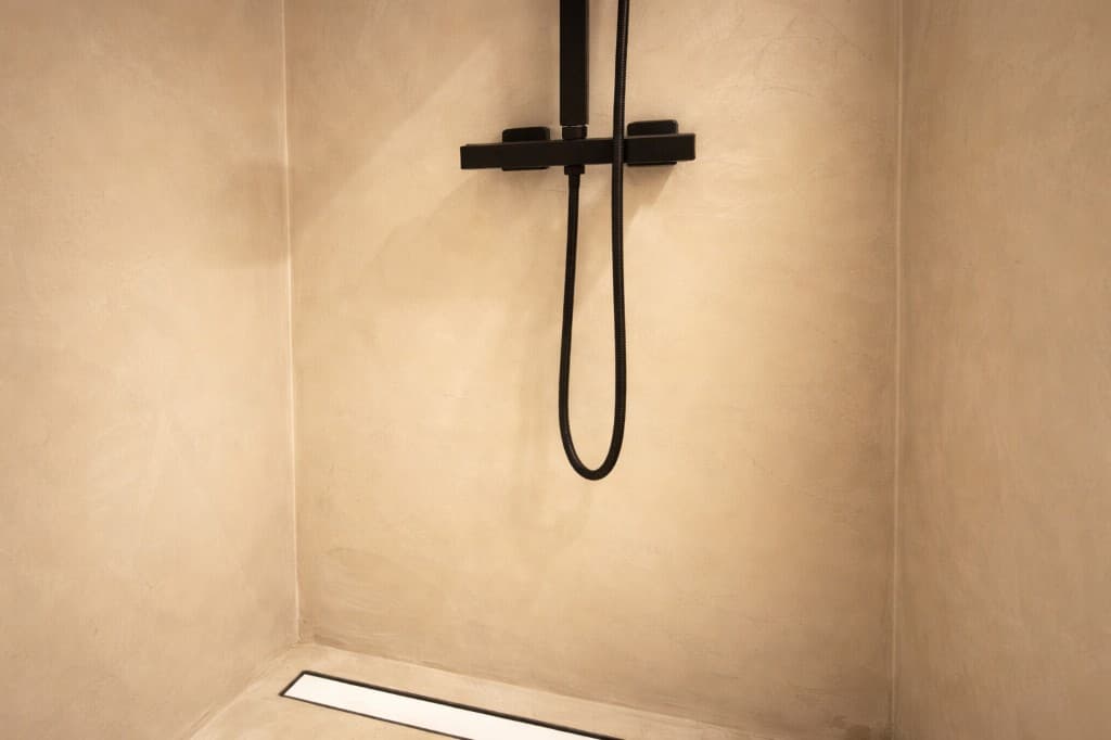 Microcemento en Granada: baño con plato de ducha continuo sin juntas