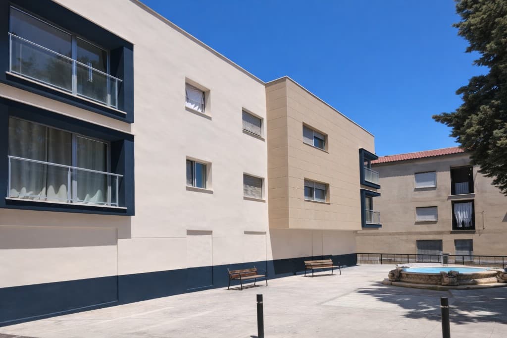 Pintura de fachadas en Granada: edificio residencial en tonos crema y azul