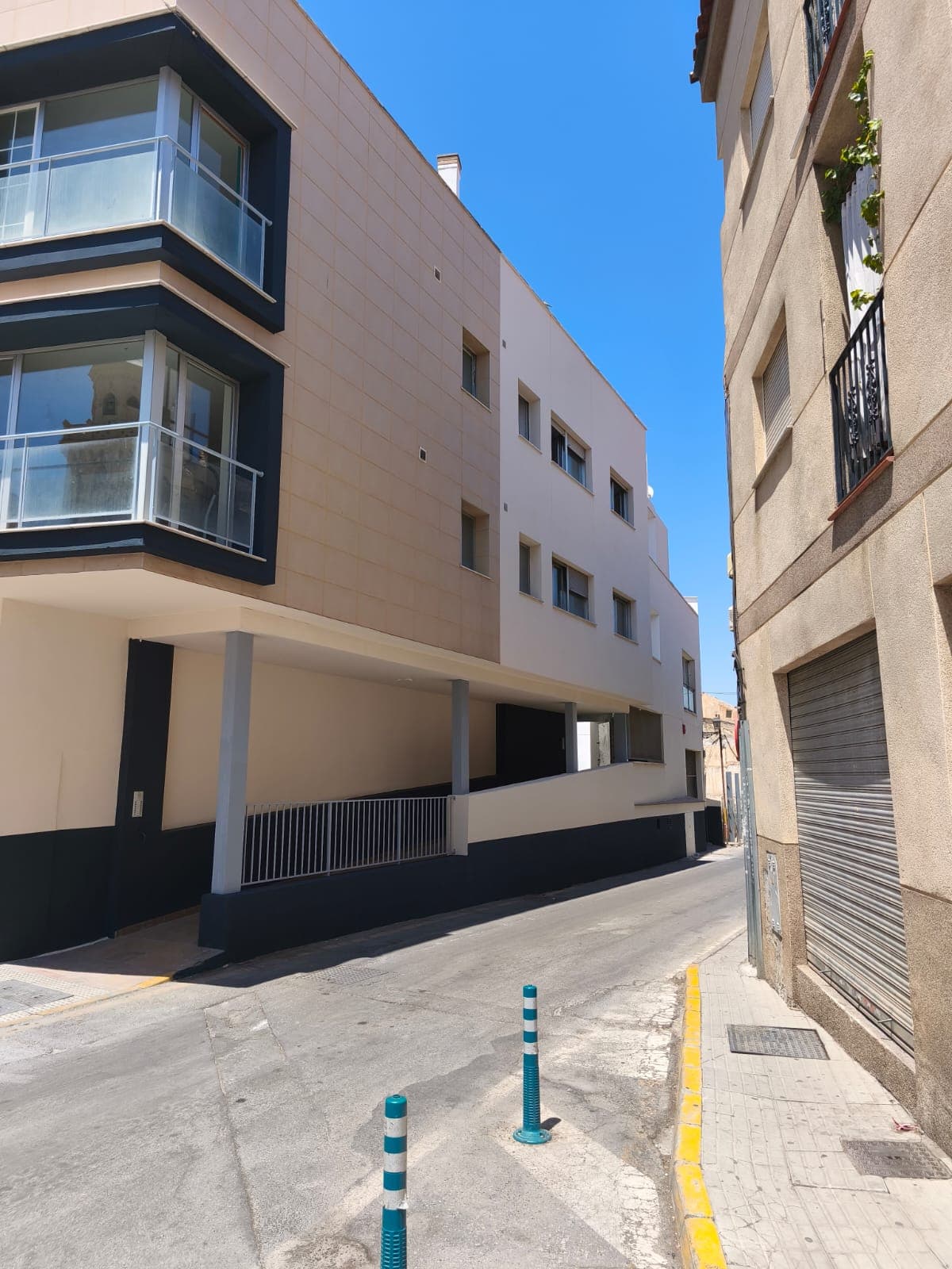 Bloque de comunidad de vecinos pintado en Granada con porche de entrada bicolor