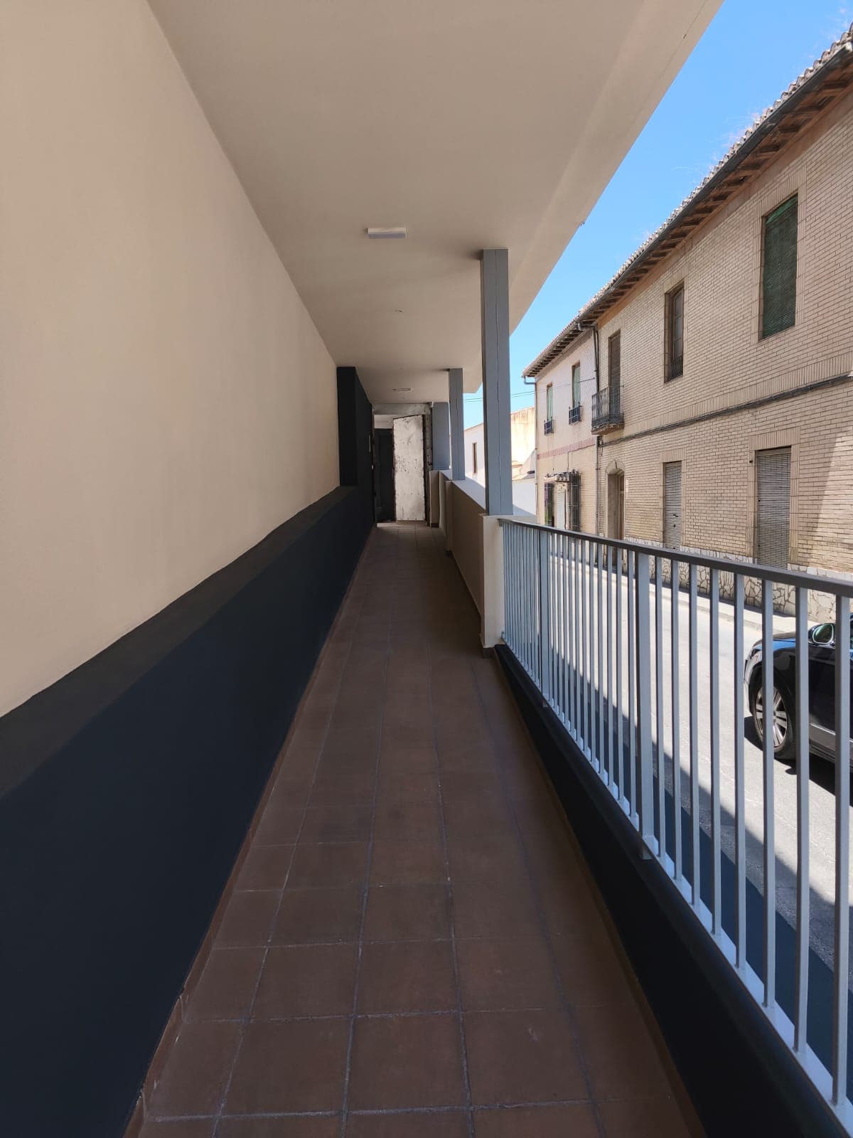 Pasillo de zona común en comunidad de vecinos pintado en crema y azul oscuro en Granada